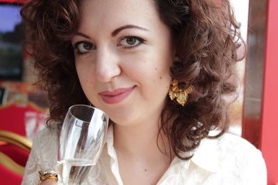 Close-up portrait of woman holding champagne flute