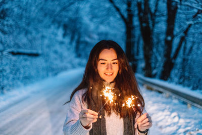 Portrait of young woman standing against trees