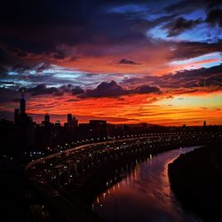 Illuminated buildings against sky during sunset