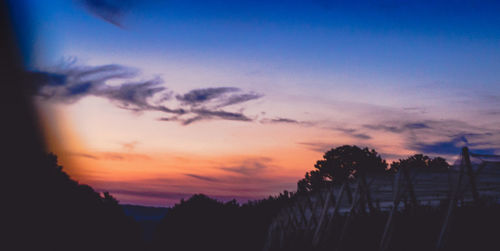 Silhouette trees against sky at sunset