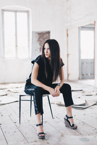 Portrait of young woman sitting on floor