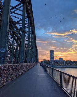 Bridge in city against sky during sunset