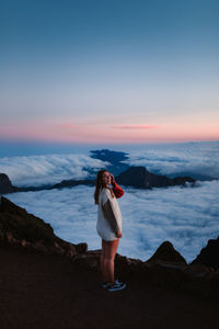 Full length of woman standing on land against sky during sunset