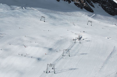 Skiing tracks and cable car road on snowed sunny slope of austria alps