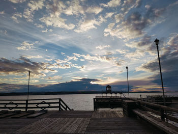 Pier over sea against sky during sunset