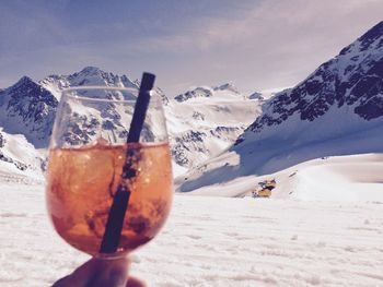 Glass of ice cream against mountains during winter