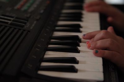 Cropped hands of child playing piano