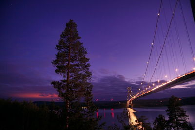 Illuminated bridge against sky at night