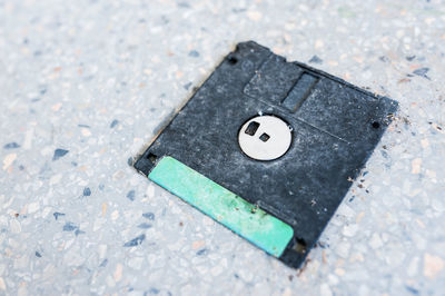 Close-up of abandoned floppy disk on footpath