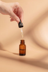 Cropped hand of person holding electronic cigarette on table