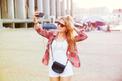 Young woman using mobile phone in city