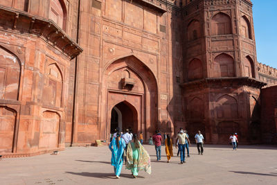 Rear view of people walking in historic building