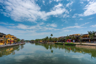 Scenic view of lake by buildings against sky