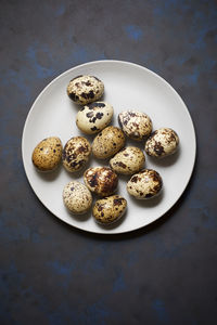 Quail eggs on a black table.