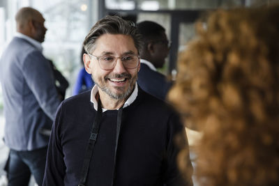 Businessman talking with female delegate during seminar at conference center