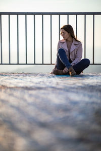 Full length of woman sitting outdoors