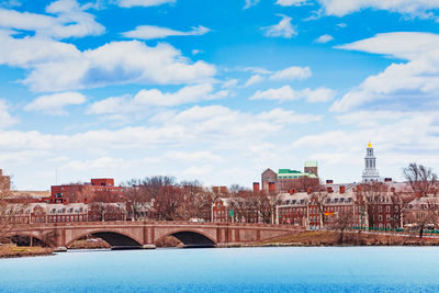 Arch bridge over river against buildings in city