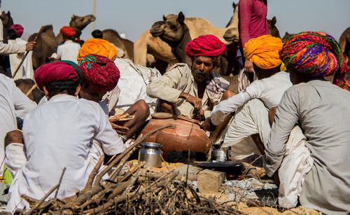 Rear view of people sitting outside temple