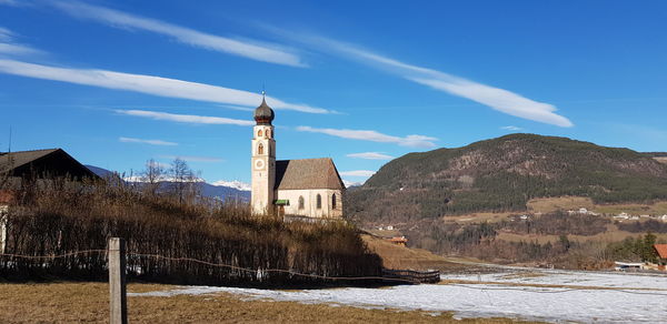 Panoramic view of buildings and mountains against blue sky