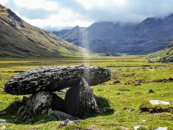 Scenic view of land and mountains against sky