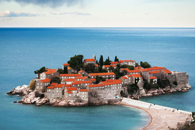 Scenic view of sea by buildings against sky