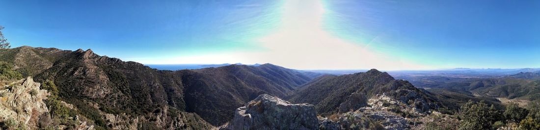 Panoramic view of mountains against blue sky