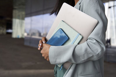 Businesswoman holding diary and technologies