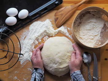 A woman kneads dough on a kitchen cutting board. a woman's hobby.food background.