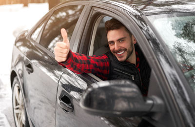 Portrait of a smiling young man in car