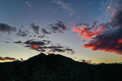 Scenic view of dramatic sky over mountains during sunset