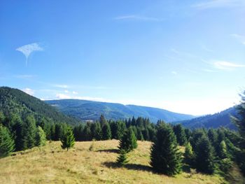 Scenic view of mountains against blue sky