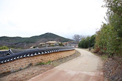 Road by bridge against sky