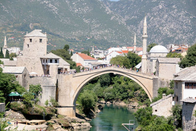 Arch bridge over river amidst buildings in city. mostar arch bridge.