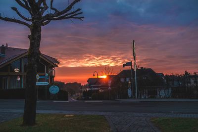 Street amidst buildings against sky during sunset