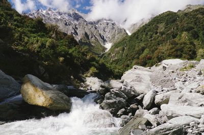 Scenic view of waterfall against mountains