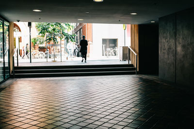 Rear view of man walking in corridor of building