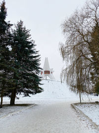 Trees and buildings against sky during winter