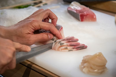 Close-up of person preparing food on cutting board