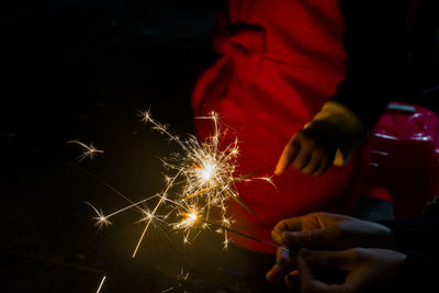 Close-up of hand holding christmas tree at night
