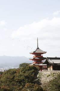 Low angle view of pagoda by building against sky