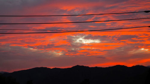 Low angle view of silhouette mountain against orange sky