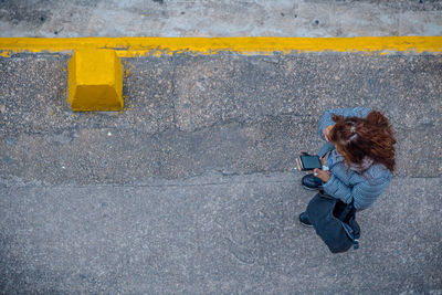 High angle view of woman using phone on road
