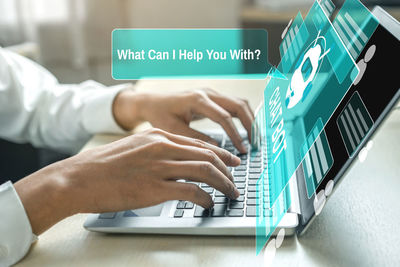 Close-up of man using laptop on table