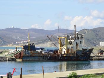 Ship in sea with mountain range in background