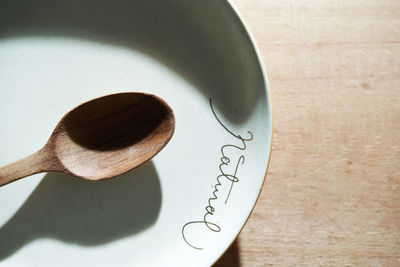 Wooden spoon on empty plate with text natural