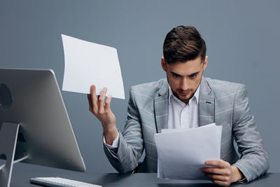 Young man using laptop while sitting on table