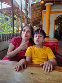 Portrait of a smiling young woman sitting on table