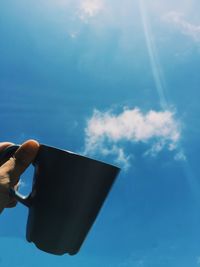 Close-up of hand holding blue sky