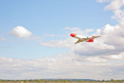 Low angle view of airplane flying against sky