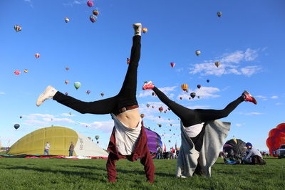 Low angle view of people flying against sky